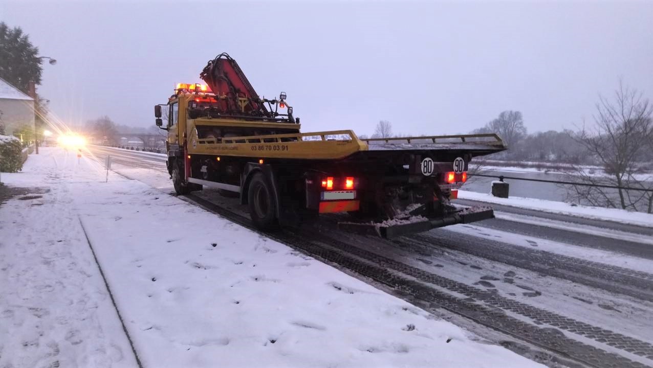 camion de dépannage en intervention sous la neige pour véhicule accidenté